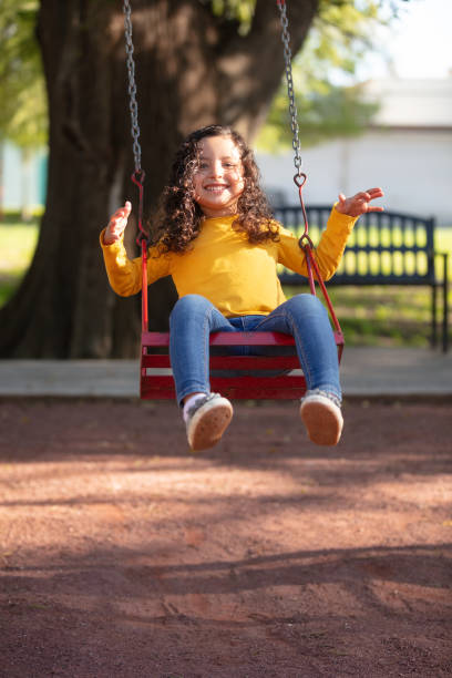 istock Little girl swinging without holding on 1159111683