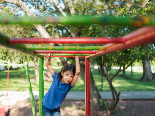 istock Cute girl playing on the monkey bars 1159111686