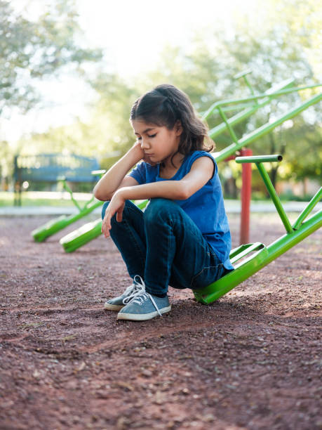 ragazza triste su un teeter totter - totter foto e immagini stock