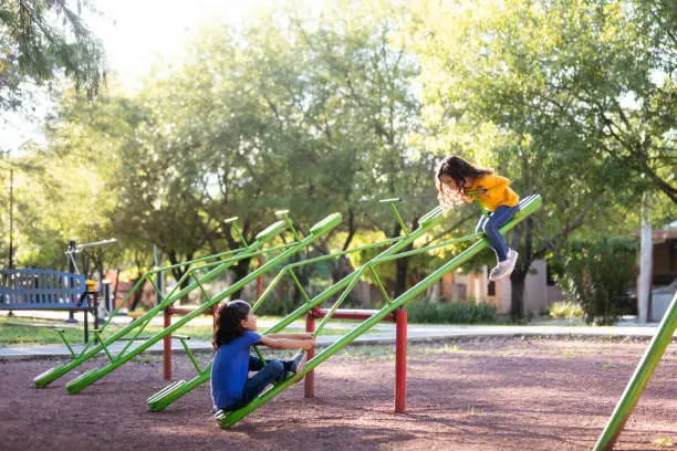 Photo of Sisters playing on a seesaw together