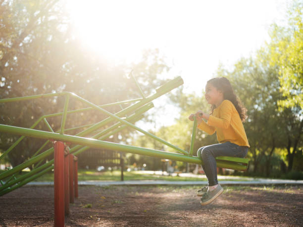 istock Girl playing on a seesaw on a sunny day 1159111709