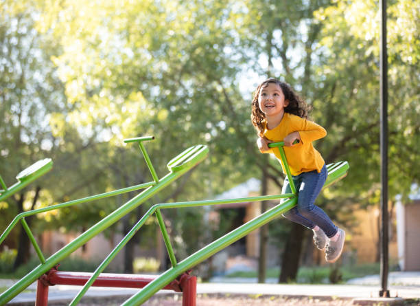 istock Exited girl playing on a seesaw 1159111712