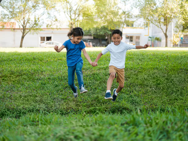 istock Little friends holding hands and jumping 1159111713