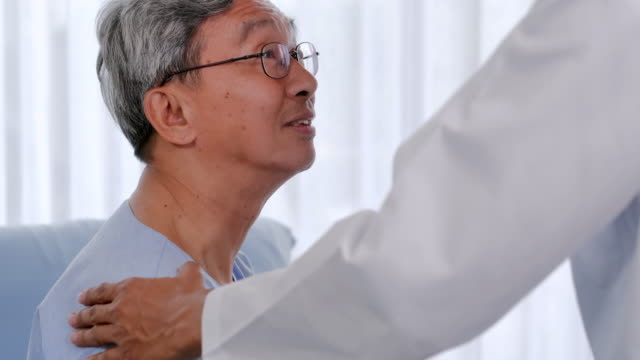 Male doctor comforting patient senior man at consulting room.Caring medical worker in hospital talking to elderly man at hospital.Medical, age, health care, cardiology and people concept.Healthcare: Caretaking