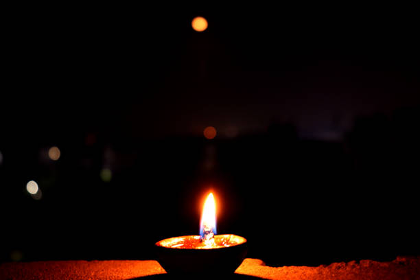 istock Traditional Clay deepak lit in front of moon. Diya and moon are in one frame 1159115342
