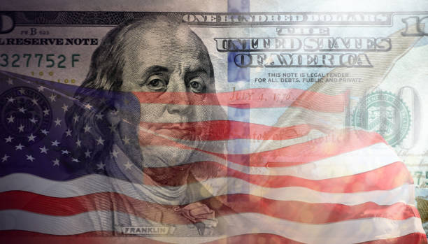 istock waving American flag and one hundred US dollar bill 1159116496