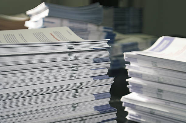 Handout Paper Piles Piles of handout papers lying on a table. bundle stock pictures, royalty-free photos & images