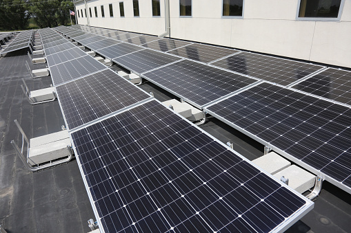 Aerial view of solar panels or solar cells on the roof of shopping mall building rooftop. Power plant, renewable clean energy source. Eco technology for electric power in industry.