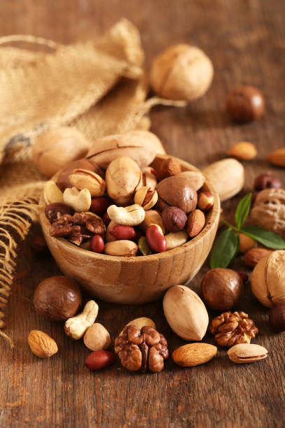 organic mix nuts organic mix nuts on a wooden table nut stock pictures, royalty-free photos & images