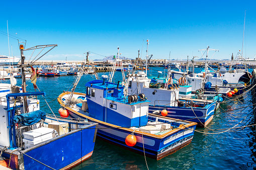 Tarifa, Spain - May 27, 2019: Port of Tarifa with fishing boats, Punta del Santo in the distance