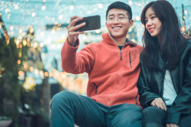 istock Asian young couple travelling and taking selfie. 1159136541
