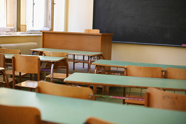 istock Empty classroom full of desks and blank chalkboard 115914135
