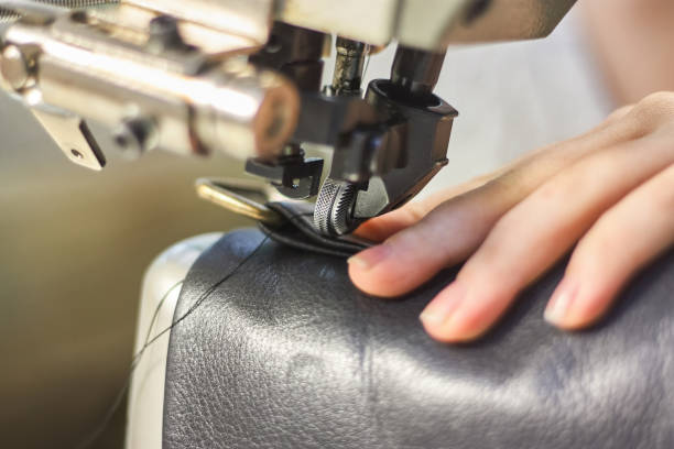 istock Sewing machine in a leather workshop in action with hands working with a leather details 1159142354
