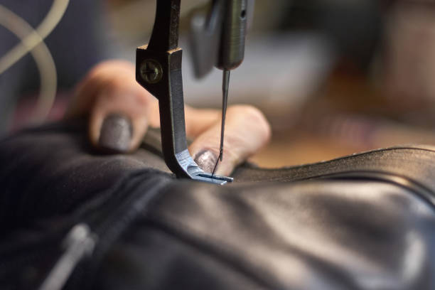 istock Sewing machine in a leather workshop in action with hands working with a leather details 1159142385