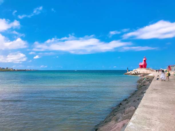 istock Blue sky white clouds blue sea red lighthouse 1159143590