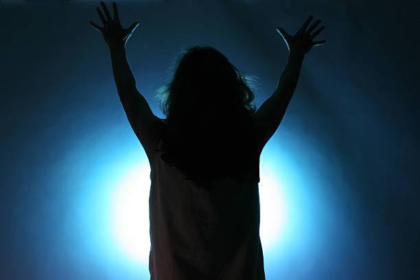 One person offering praise with uplifted hands