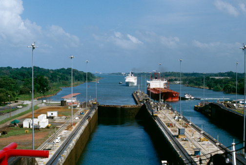 Ships entering Gatun Locks from the Atlantic in the Panama Canal. Ship on right is Panamax bulk vessel and carries grain, ship on left is a cruise ship.