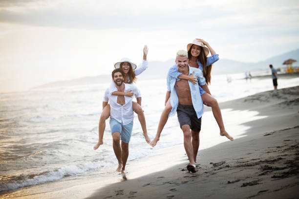 istock Friends having fun on the beach under sunset sunlight. 1159161745