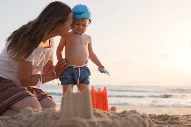 istock Mother and son on the beach playing with sand 1159161903