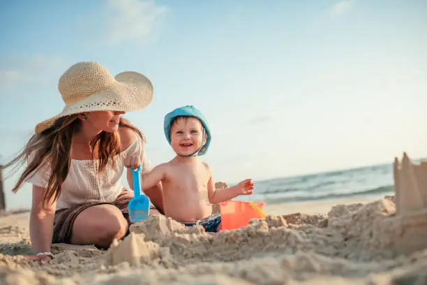 Family building a sandcastle on the beach  in summer