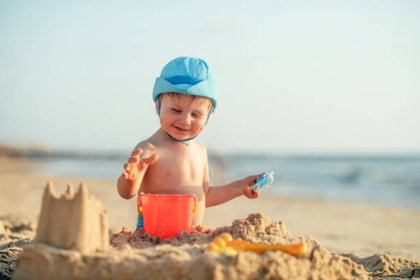 istock Happy little boy building sandcastle on the beach 1159161949