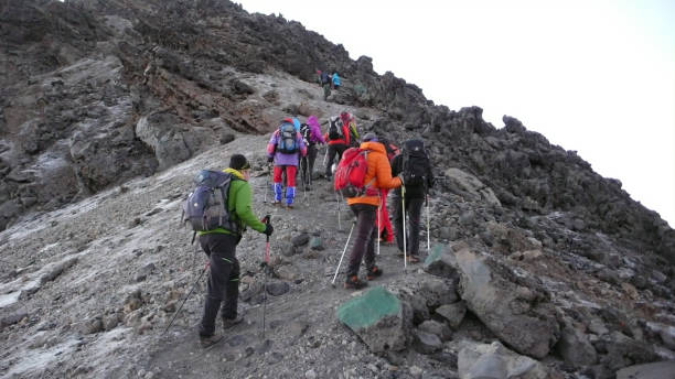 de nombreux alpinistes marchent vers le sommet du mont meru dans le parc national d'arusha en tanzanie - uhuru peak photos et images de collection
