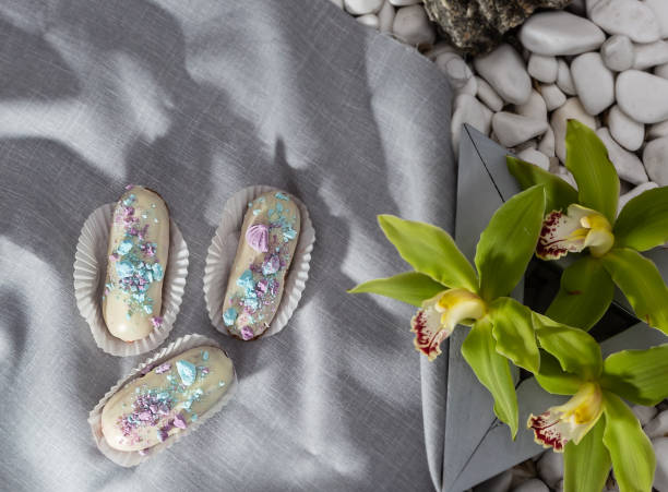 Tasty eclairs on wooden table, close up