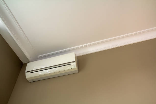 istock Cool air conditioner installed in room interior on white ceiling and light walls copy space background. Climate control, comfortable home concept. 1159167418