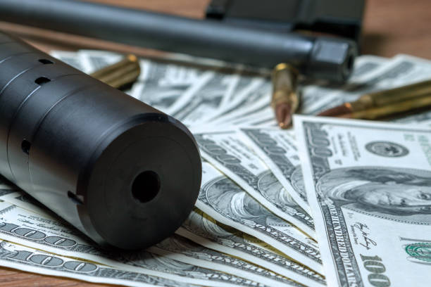 istock Rifle barrel, suppressor and cartridges on dollars 1159168765