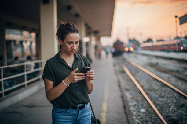 in attesa di messaggi di treno e sms - ponytail brown hair tourist women foto e immagini stock