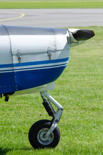 Nose with nose wheel of a single-engine plane on a small sport airfield on the grass