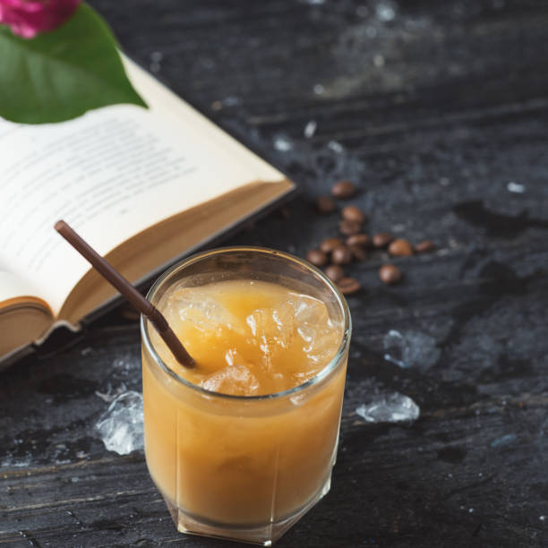 istock Iced cold coffee on an old wooden table with a book. Summer morning 1159172001