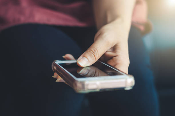 istock hipster woman using hands touching and typing on mobile phone screen search internet online working or social communication with digital technology app device in coffee shop indoor vintage lifestyle. 1159172125
