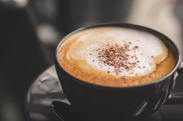 istock close up modern hot black coffee the cappuccino on dark background with coffee bubble foam pattern and texture in black cup looking and feel so delicious on glasses table in coffee shop. 1159172155