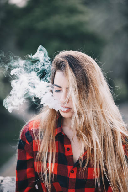 istock Young blond woman portrait vaping 1159172315