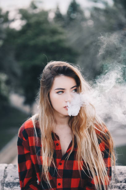 istock Young blond woman portrait vaping 1159172329