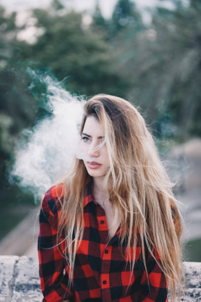 istock Young blond woman portrait vaping 1159172330