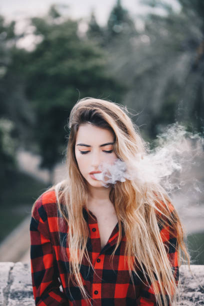 istock Young blond woman portrait vaping 1159172913