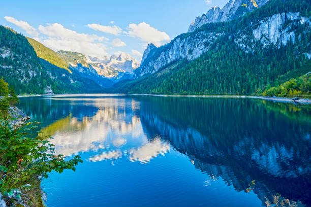 istock Beautiful Gosausee lake landscape with Dachstein mountains, forest, clouds and reflections in the water in Austrian Alps. Salzkammergut region. 1159172929
