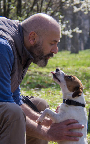 istock Man playing with his dog in a park during Spring time 1159175353