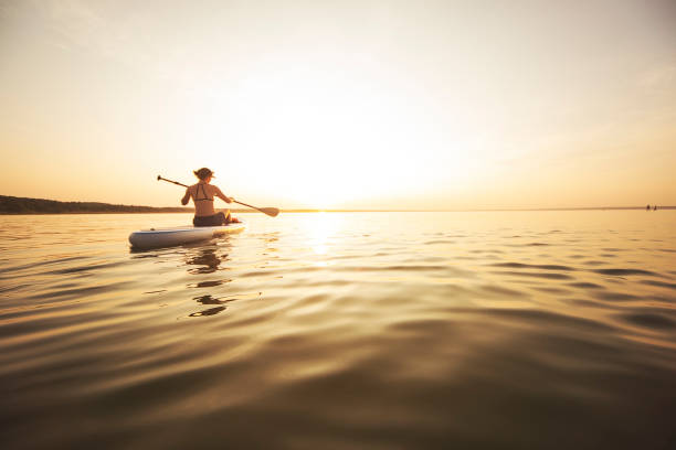 istock Young adult woman paddle boarding 1159175449
