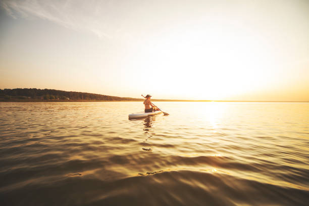 istock Young adult woman paddle boarding 1159175477