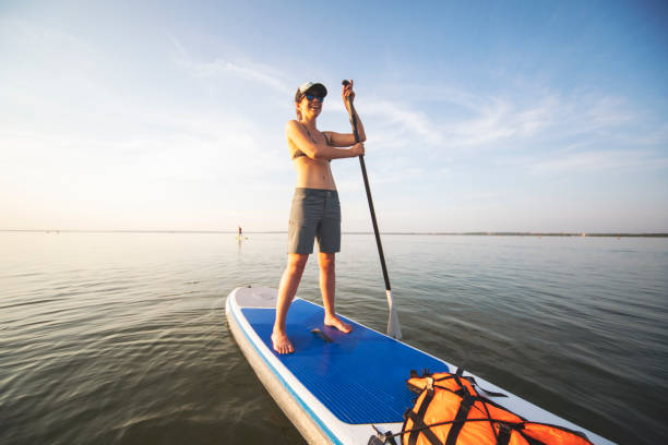 istock Young adult woman paddle boarding 1159175542