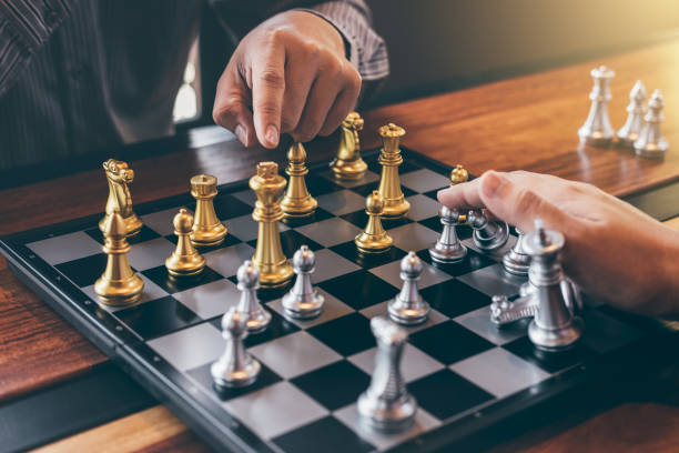 istock Intelligent businessman playing chess game competition with the opposite team, planning business strategic to development for win and success, Gold and silver chess with player 1159177200