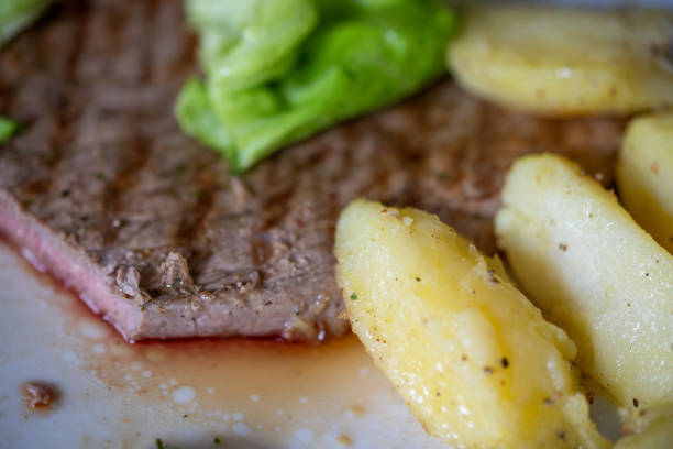 The vegetable salad in beef steak and French fries with cheese bread in white plate on white background