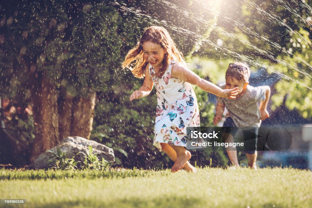 Glückliche Kinder spielen mit Garten Sprinkler - Lizenzfrei Kind Stock-Foto