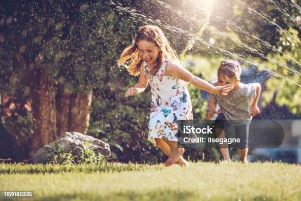 Happy Kids Playing With Garden Sprinkler Stock Photo - Download Image Now - Child, Summer, Yard - Grounds