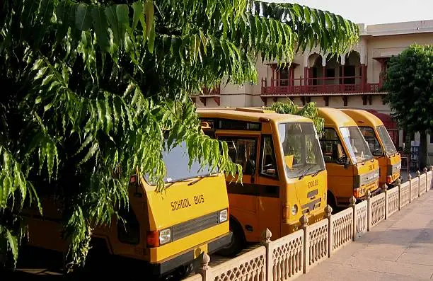 4 School Buses waiting in Carpark at City Palace, Jaipur, Rajasthan, India