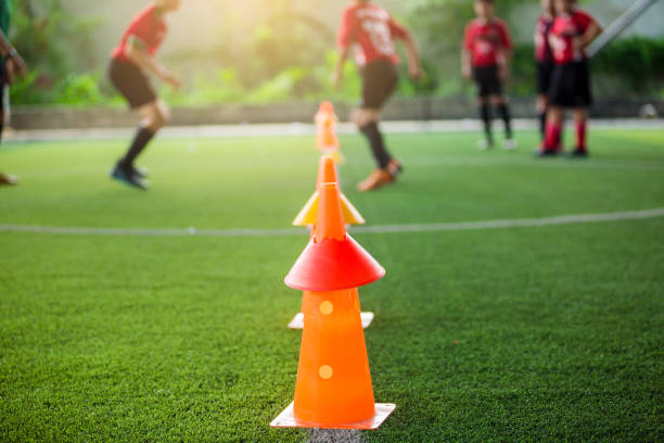 istock orange marker cones on green artificial turf for soccer training. 1159180653
