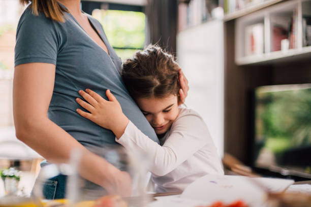 istock Girl hugging pregnant woman's belly 1159181132